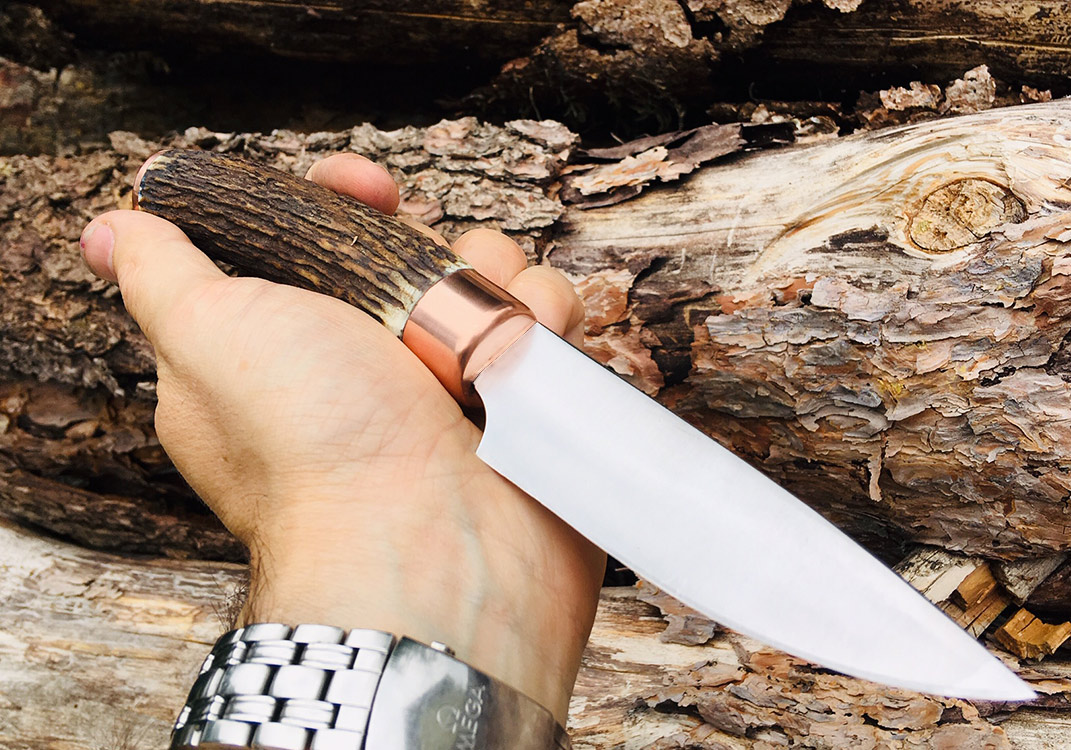 Jagdmesser aus 80CrV2, Hirschhorn, Kupferzwinge und -endkappe.
Verklebt und vernietet.