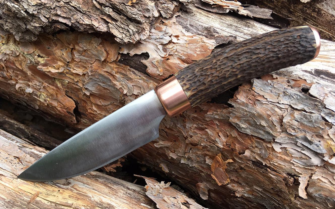 Jagdmesser aus 80CrV2, Hirschhorn, Kupferzwinge und -endkappe.
Verklebt und vernietet.