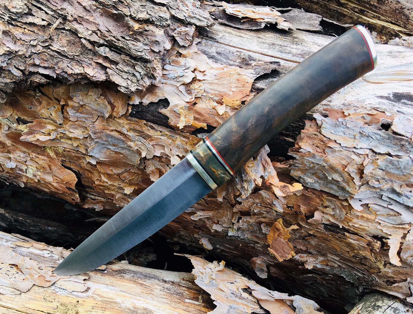 Kleiner Puukko-Verschnitt.
Klinge aus 80CrV2, Griff aus Neusilber, Fiber, Birke, Walnuss.
Verklebt und vernietet.